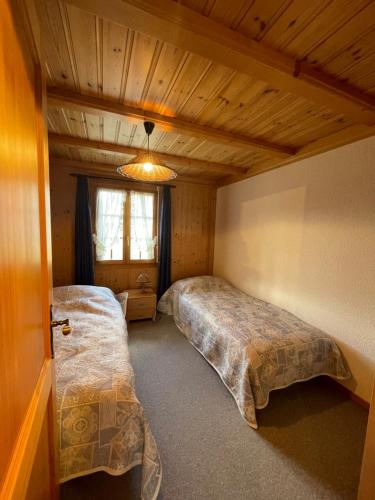 um quarto com 2 camas e uma janela em Gerendacherli 15 em Schwarzsee