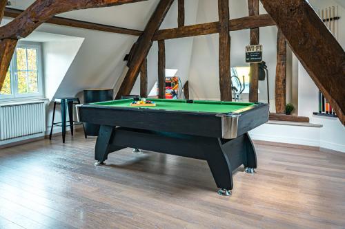 a pool table in the middle of a room at Gite 4 étoiles - Au p'tit bonheur Normand in Bourth
