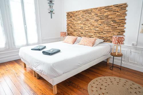 a bedroom with a large bed with a brick wall at Gite 4 étoiles - Au p'tit bonheur Normand in Bourth