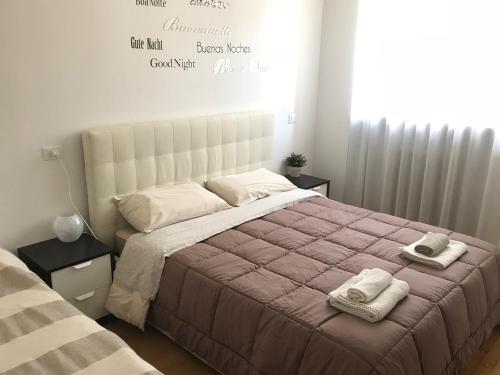 a bedroom with a large bed with two towels on it at The Little House in Bergamo in Bergamo