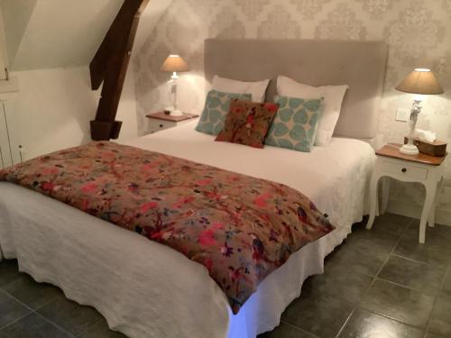 - une chambre avec un grand lit blanc et une couverture rouge dans l'établissement La Maison Bleue, à Juillac