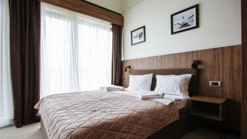 a bedroom with a bed with two books on it at Rtanj Kopaonik Eco Resort & Spa in Kopaonik
