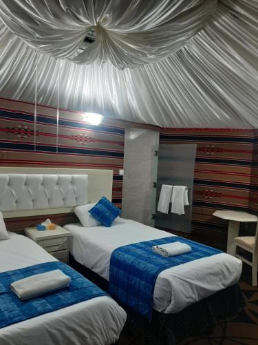 a bedroom with two beds and a tent at The Rock Camp Petra in Wadi Musa