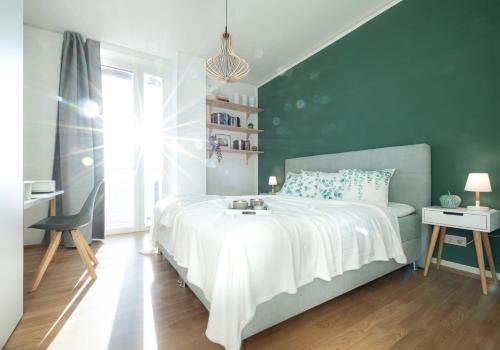 1 dormitorio con 1 cama con pared verde en New Luxury apartment overlooking Vienna, en Viena