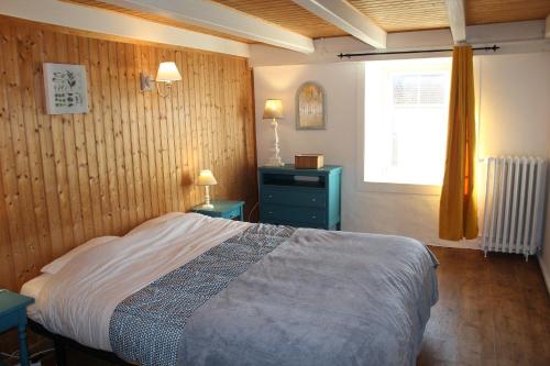 ein Schlafzimmer mit einem Bett, zwei Tischen und einem Fenster in der Unterkunft La BLAUDIERE in Mouchamps
