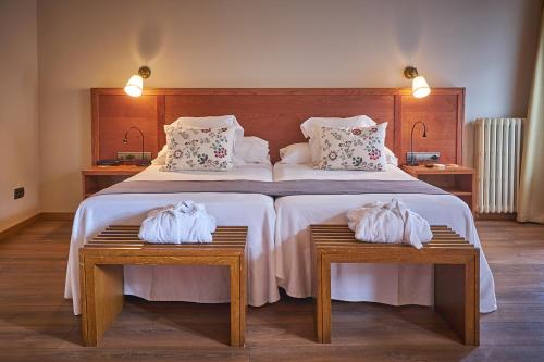 a bedroom with a large bed with two tables with towels at Hotel-Hostal Sport in Falset