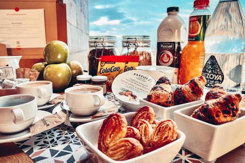 una mesa cubierta con platos de comida y bebida en Enjoybcn Dali Apartments, en Barcelona