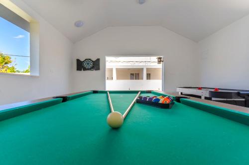 a billiard room with a pool table with balls at Apartments and Rooms Villa Niko in Trogir