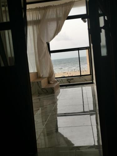 una puerta abierta con vistas a la playa en Résidence Maty - 2 chambres salon en Grand Médina