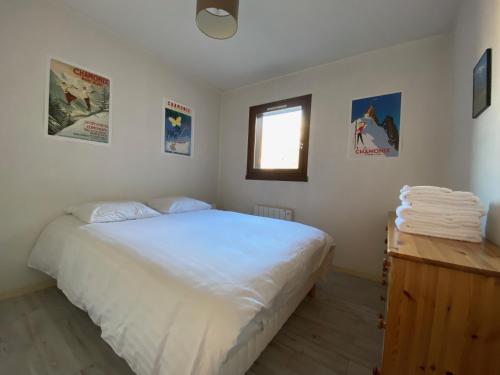 une chambre avec un lit blanc et une fenêtre dans l'établissement Aster, à Chamonix-Mont-Blanc