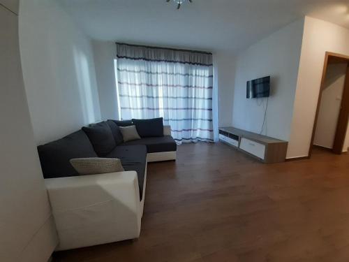 ein Wohnzimmer mit einem Sofa und einem TV in der Unterkunft Beach Home in Keszthely