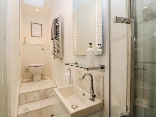 Un baño blanco con lavabo e inodoro. en 23 Daniel Street, en Bath