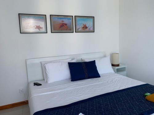 a bedroom with a bed with three pictures on the wall at Nilaveli Beach Apartment Sri Lanka in Nilaveli
