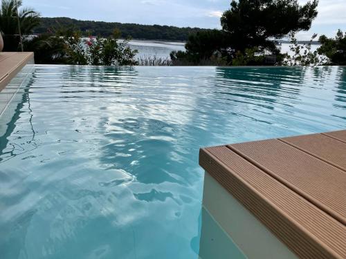 a swimming pool with a view of the water at Villa del Mar in Mali Lošinj