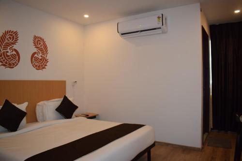 a hotel room with a bed and a air conditioner at Vishnu Paradise in Mohammadnagar