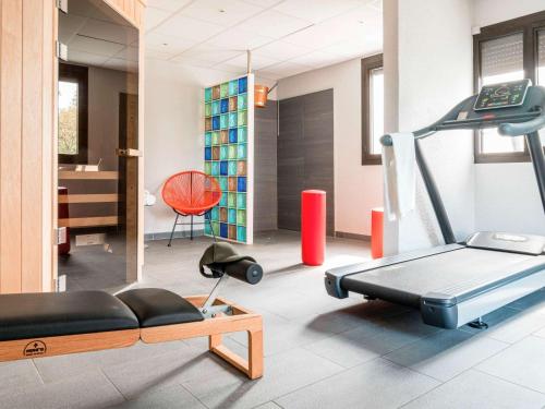 a room with a gym with a treadmill and a chair at Ibis Styles Toulouse Labège in Labège