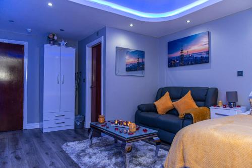 a bedroom with a bed and a couch and a table at Meridian Serviced Apartments in Bradford
