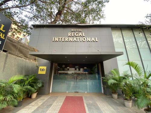 Hotel Regal International - Near Mumbai International Airport Andheri East في مومباي: مبنى عليه لافته تقول فندق عالمي حقيقي