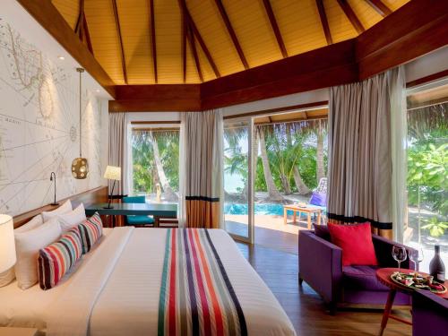 加弗阿利夫环礁Mercure Maldives Kooddoo - Adults - Only Escape - 50 percent off Transfers的一间带大床的卧室和一个游泳池