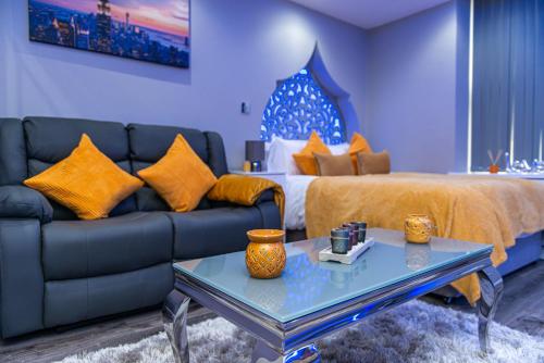 a living room with a couch and a bed at Meridian Serviced Apartments in Bradford