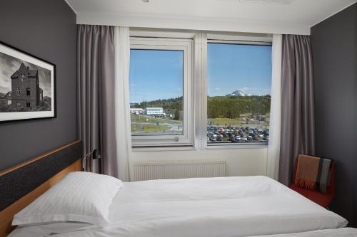 a bedroom with a bed and a large window at Reykjavik Natura - Berjaya Iceland Hotels in Reykjavík