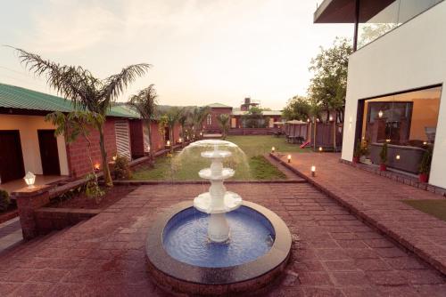 a fountain in the middle of a courtyard at La Serene Resort and Spa in Mahabaleshwar