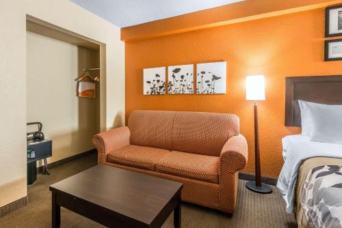 a hotel room with a chair and a bed at Sleep Inn & Suites Ocala in Marion Oaks