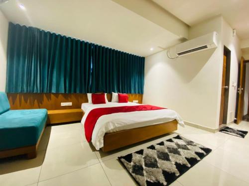 ein Schlafzimmer mit einem großen Bett und einem blauen Vorhang in der Unterkunft Hotel Prime in Gandhinagar