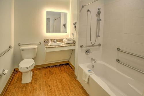 a bathroom with a toilet and a tub and a sink at LeConte Hotel & Convention Center, Ascend Hotel Collection in Pigeon Forge