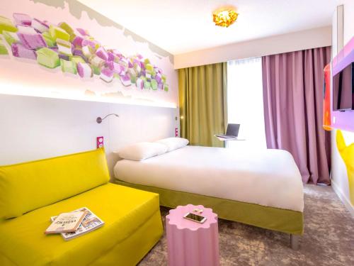 een hotelkamer met een bed en een bank bij ibis Styles Fréjus St Raphael in Fréjus