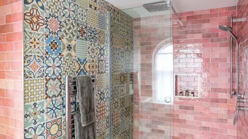 a bathroom with a shower with tiles on the wall at The Bear Hotel in Wareham