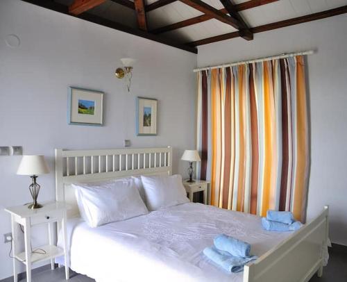 Un dormitorio con una cama blanca y una ventana. en Magnolia Apartment, en Centro histórico de Alónnisos