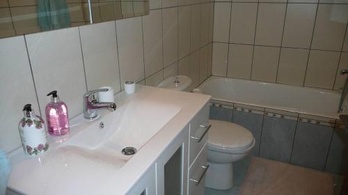 Un baño con lavabo, inodoro y bañera. en Magnolia Apartment, en Centro histórico de Alónnisos