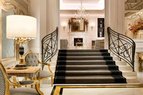 a lobby with a staircase with a lamp and chairs at Hotel Splendide Royal - The Leading Hotels of the World in Rome