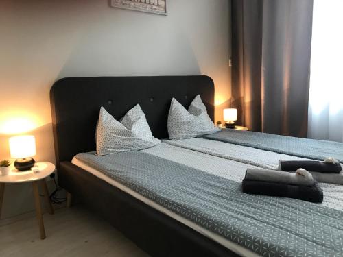 1 dormitorio con 1 cama grande con almohadas blancas en Bervia Apartman, en Szombathely