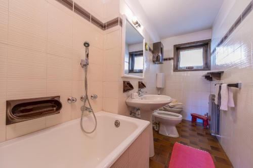 La salle de bains est pourvue d'une baignoire, d'un lavabo et de toilettes. dans l'établissement Casa Cisi ski in-Ski out 20m - Happy Rentals, à Livigno