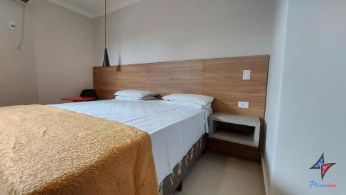 a bedroom with a large bed with a wooden headboard at Hotel PrimeInn in Campinas