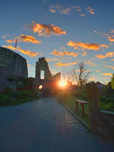 a sunset with a bench and a building in the background at Hexenhäuschen Dreieichenhain in Dreieich