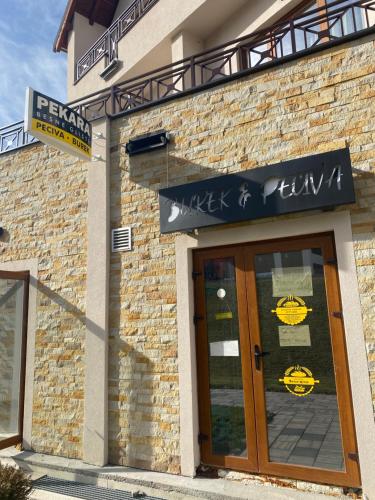 um edifício de tijolos com uma placa por cima de uma porta em KopLux Milmari Spa em Kopaonik