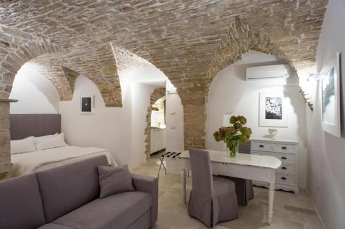 Sala de estar con cama, sofá y mesa en LE SUITES AL TORRIONE, en Ruvo di Puglia