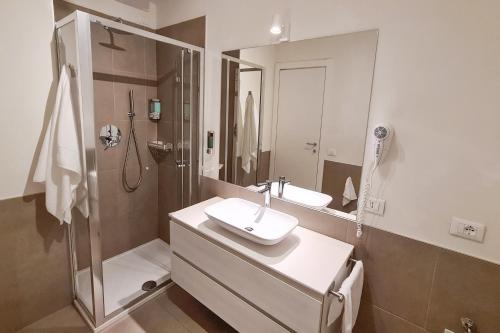 een witte badkamer met een wastafel en een douche bij PORTA NUOVA - Casa Vacanze Ai Mille - 3 in Bergamo