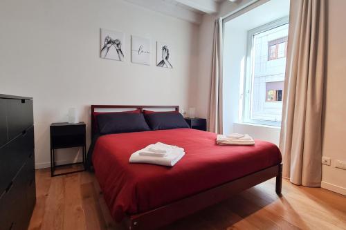 een slaapkamer met een rood bed en 2 handdoeken erop bij PORTA NUOVA - Casa Vacanze Ai Mille - 3 in Bergamo