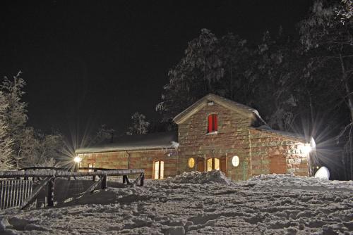 a barn in the snow at night at Chalet Vecchio Rifugio - Monte Amiata in Castel del Piano