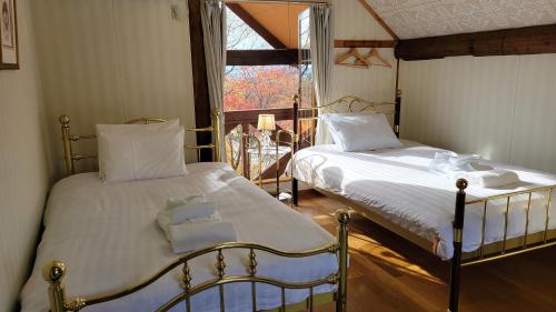 a bedroom with two beds and a window at フォレスト倶楽部　田園 in Takano