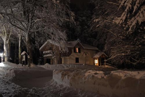 a house with lights on in the snow at night at Chalet Il Cristallo-Monte Amiata in Castel del Piano