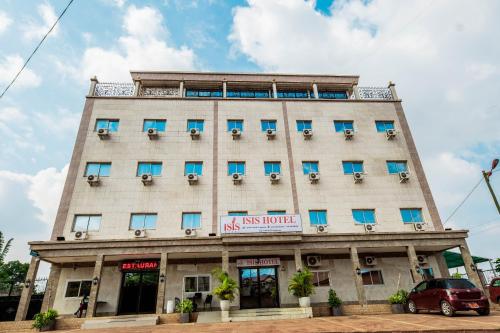 - un grand bâtiment blanc avec des fenêtres bleues dans l'établissement ISIS Hôtel, à Yaoundé