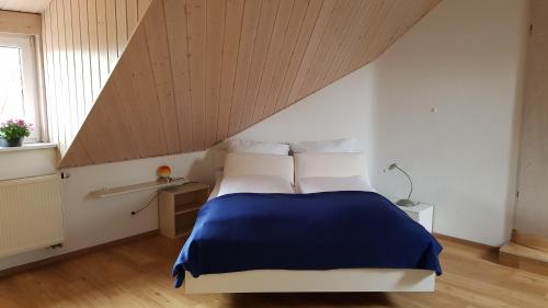 una camera da letto con letto blu e bianco in mansarda di Apartment Kern Lautrach a Lautrach
