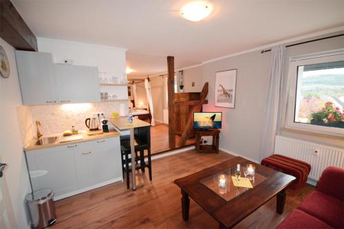 a kitchen and a living room with a table in a room at Sieben-Berge-Haus in Brüggen