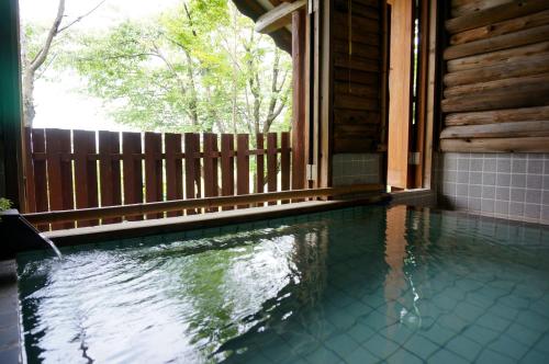 a swimming pool in the side of a house at フォレスト倶楽部　田園 in Takano