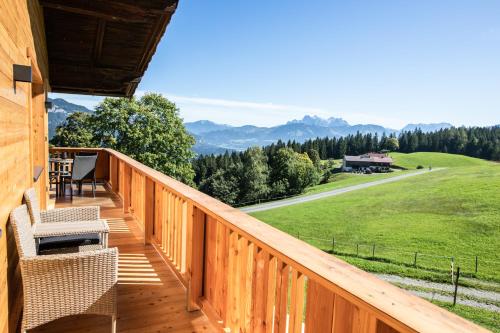 une terrasse avec des chaises et une vue sur un champ dans l'établissement Apartment zu Hollenau, à Going am Wilden Kaiser